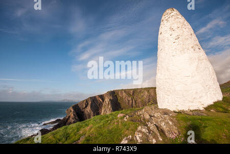 Un cairn de pierre blanchis à la chaux se trouve sur la côte de Pembrokeshire clifftops sur marquant l'entrée du port de Porthgain. Banque D'Images