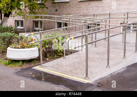 Rampe concret avec main courante en acier inoxydable avec mobilité signe pour soutenir les personnes handicapées en fauteuil roulant. Concept de soins de santé.l'extérieur du bâtiment rampe d'escalier métallique Banque D'Images