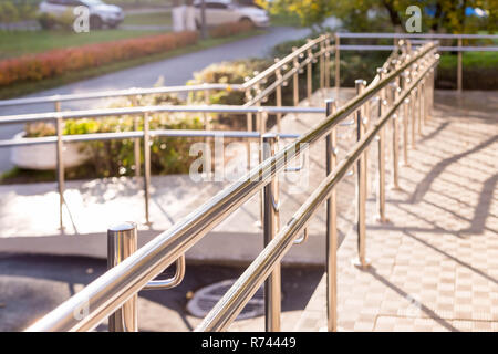 Rampe concret avec main courante en acier inoxydable avec mobilité signe pour soutenir les personnes handicapées en fauteuil roulant. Concept de soins de santé.l'extérieur du bâtiment rampe d'escalier métallique Banque D'Images