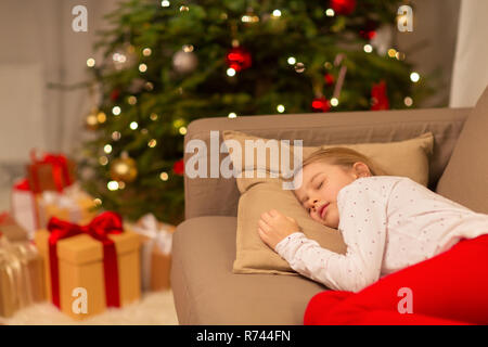 Girl sleeping on sofa at Christmas Banque D'Images