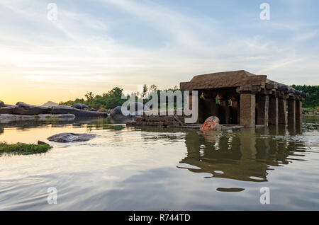 La moitié d'un temple en pierre avec structure immergée partiellement visible dans la rivière Tungabhadra Hanuman idol, Hampi, Karnataka, Inde Banque D'Images