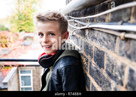 Boy leaning against the brickwall Banque D'Images