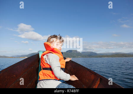 Garçon à la recherche de retour de l'avant du bateau à rames, Aure, More og Romsdal (Norvège) Banque D'Images