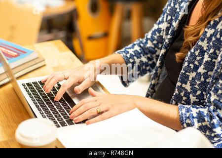 Pregnant woman typing on laptop at table de cuisine, cropped Banque D'Images