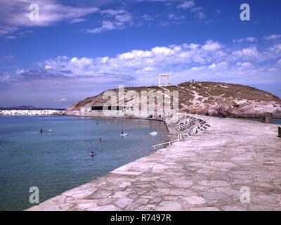 Avis de Portara ou temple d'Apollon sur l'île de Palatia à côté de l'île de Naxos et les gens nager dans la mer Banque D'Images