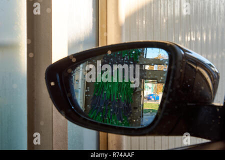 Photo en gros plan d'un rétroviseur à l'intérieur d'un lavage de voiture avec de l'eau gouttes Banque D'Images