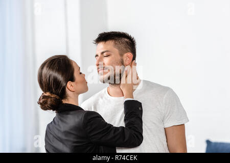 Petite amie en cause va baiser petit ami en pyjama dans la chambre au matin, à la semaine, l'égalité concept Banque D'Images