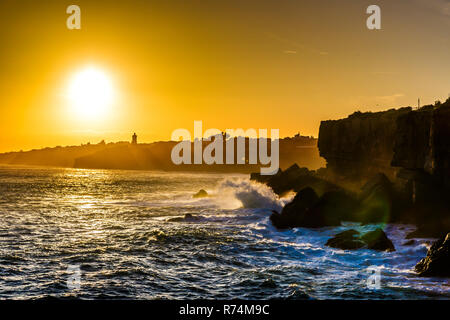 Incroyable coucher du soleil avec des vagues se brisant sur les falaises de Cascais au Portugal Banque D'Images