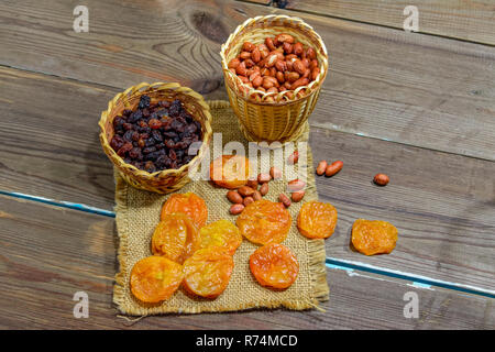 Les cacahuètes fraîches pelées abricots secs Raisins secs sur une table en bois historique close-up Banque D'Images