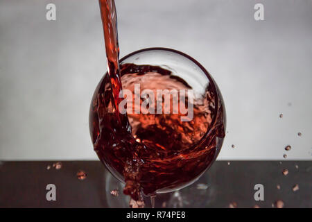 Façon intéressante pour verser le vin et de s'éclabousser dans un verre Banque D'Images