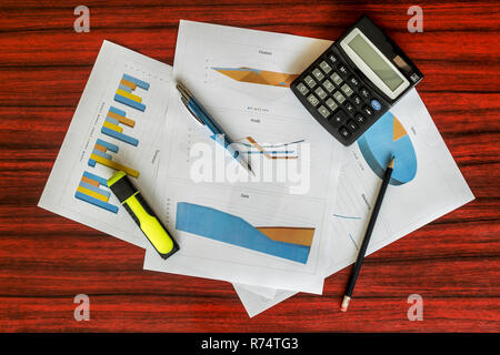 Groupe d'impression de graphiques avec calculatrice, trombones et un stylo sur eux Banque D'Images