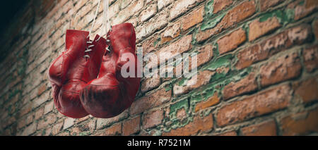 Old Red boxing gloves accrocher au clou sur mur de briques avec copie espace pour le texte. Rendu 3D haute résolution Banque D'Images