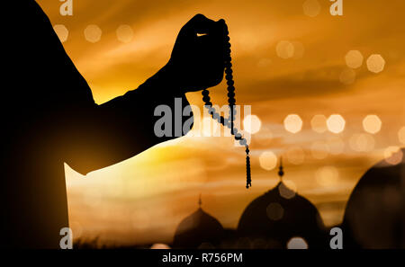 Silhouette de musulman en prière avec le chapelet Banque D'Images