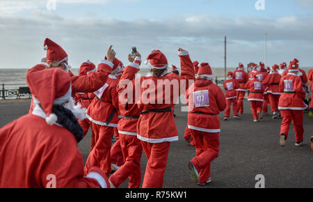 Brighton, Sussex, UK. Le 08 décembre 2018. Des centaines de Santas prendre part à l'exercice annuel Brighton Santa Dash le long du front de mer à Hove la collecte de fonds pour l'organisme de bienfaisance local Rockinghorse . Rockinghorse est un organisme de bienfaisance de la région de Brighton qui a été d'aider les enfants à Sussex depuis plus de 50 ans. Crédit : Simon Dack/Alamy Live News Banque D'Images