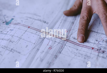 Les mains d'un homme sur une carte graphique. Étude de la formule de pipelines. Banque D'Images