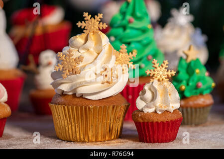 Divers Noël coloré cupcakes avec fond de bois et d'arbres de Noël Banque D'Images