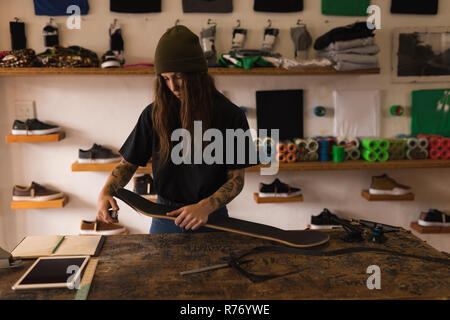 Femme de la réparation en atelier de planche à roulettes Banque D'Images