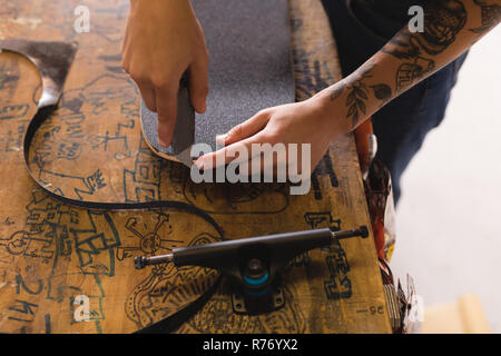 Femme de la réparation en atelier de planche à roulettes Banque D'Images