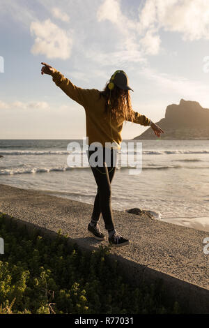 Femme marche sur le mur près de la plage Banque D'Images