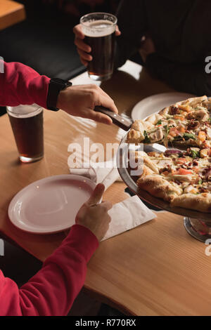 La prise de l'homme tranche de pizza à partir du bac Banque D'Images