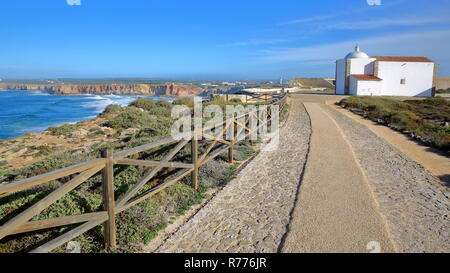 Vue depuis l'allée pavée à la Forteresse de Sagres avec l'église de Notre Dame de grâce et de la plage de Tonel en arrière-plan, Algarve, Portugal Banque D'Images