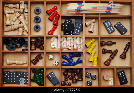 Figures en bois de jeux de société, jeux de pièces, dés, dominos, bâtonnets de Mikado, la collection de jeux dans une lettre cas Banque D'Images