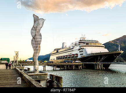 Sculptures abstraites en métal le long du quai du port de navires de croisière, avec des navires amarrés en arrière-plan, en fin d'après-midi au chaud soleil, Juneau, Alaska, USA. Banque D'Images