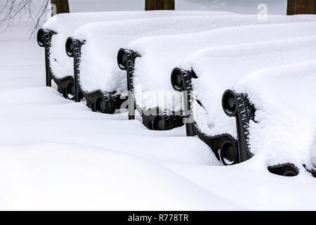 Rangée de bancs en bois dans le parc couvert de neige Banque D'Images