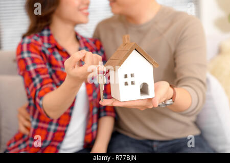 Heureux couple holding pour nouvelle maison et chambre miniature - concept immobilier Banque D'Images