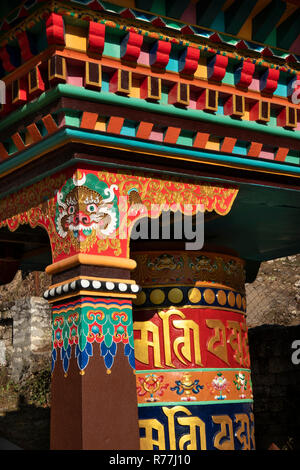 Le Népal, Namche Bazar, décoration colorée sur la prière bouddhiste fonctionnant à l'eau roues auprès d'chemin principal en ville Banque D'Images