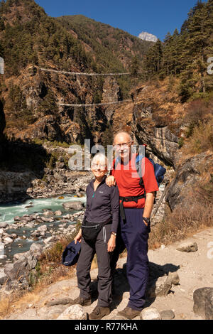 Le Népal, Larja Dobhan, senior trekkers sur Everest Base Camp Trek reposant à Larja supérieur et inférieur au débit rapide, ponts traversant la rivière Dudh Sculpture khosi Banque D'Images