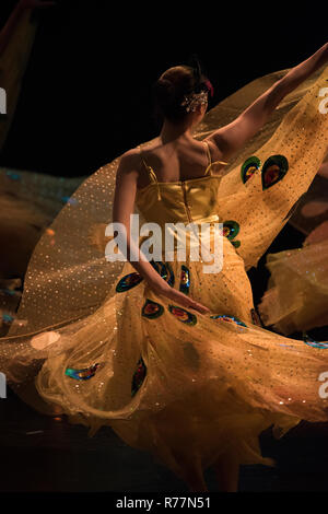 Asian woman dancing in belle robe jaune à motifs dans le cadre d'une célébration de la culture chinoise au Canada, avec vue de l'arrière et l'essorage Banque D'Images