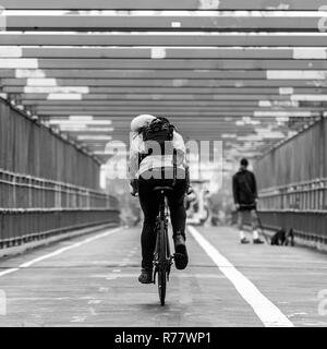 Man riding son vélo dans la voie cyclable sur le pont de Williamsburg, Brooklyn, New York. Banque D'Images