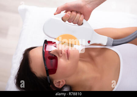 Close-up of Main Esthéticienne Épilation Au Laser de traitement visage jeune femme Banque D'Images