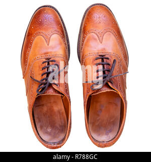 Tan brogues découper sur un fond blanc. Mens chaussures en cuir brun utilisé tourné à partir de ci-dessus. Banque D'Images