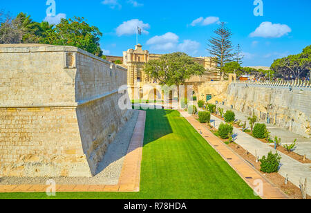 Promenade le long de l'immense ville de vieux murs de Mdina, entouré par le parc pittoresque, avec une vue sur l'historique Bastion de Redin, Malte Banque D'Images