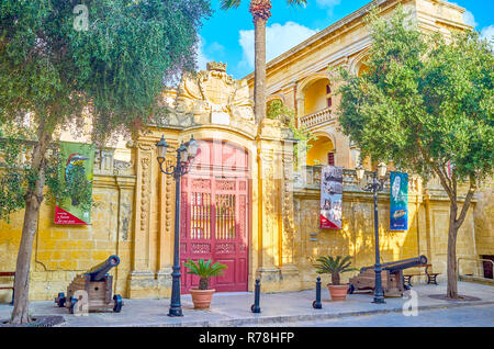 MDINA, MALTE - Juin 14, 2018 : les belles portes d'entrée sculptées à Palazzo Vihena et deux canons montés sur des plates-formes en bois, le 14 juin à Mdina. Banque D'Images