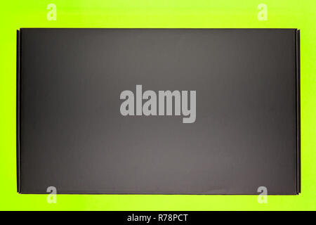 Les boîtes avec des cadeaux pour la maison de vacances enveloppé dans du papier kraft avec des arcs d'or se trouvent sur un fond vert sombre entre confetti Banque D'Images