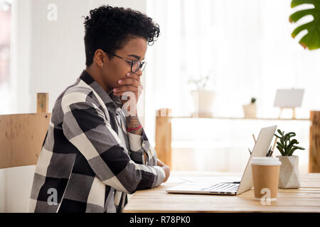 Contrarié black girl looking at laptop la réception de mauvaises nouvelles Banque D'Images