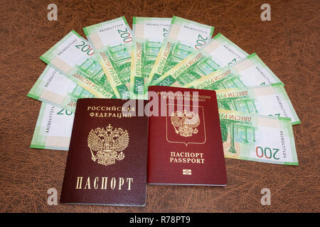 Close up de passeport russe avec de nouveaux billets valeur nominale 200 roubles sur le bureau en bois Banque D'Images