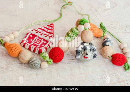 Jouets tricotés et hérisson de Noël en céramique chambre.Des jouets pour le bébé assis dans un harnais.Sling collier. Banque D'Images