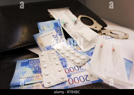 Les menottes et les pilules et les médicaments sur la table en bois Banque D'Images