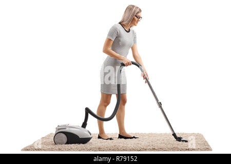 Tourné sur toute la longueur d'une femme le nettoyage d'un tapis avec un aspirateur isolé sur fond blanc Banque D'Images