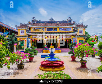 Vue magnifique sur la pagode Chua Phap Bao par une cour-jardin avec fleurs et arbres Bonsais, Hoi An, Vietnam Banque D'Images