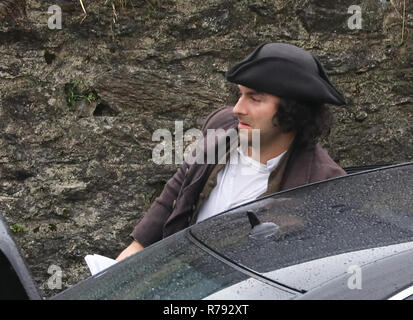 Aiden Turner promenades autour de l'ensemble dans le port avec un mystère dame et l'aide à le navire amarré, plus tard dans la scène son écran femme joué par Eleanor Tomlinson boards le bateau. Les acteurs doivent faire face à une pluie torrentielle que les derniers jours de tournage se produit pour la toute dernière série de 'Poldark' par la BBC. Comprend : Aiden Turner Où : St Austell, Royaume-Uni Quand : 07 Nov 2018 Crédit : David Sims/WENN.com Banque D'Images