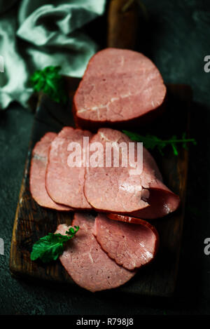 La coupe d'un boeuf fumé sur une planche à découper. Rustique de style. Selective focus Banque D'Images