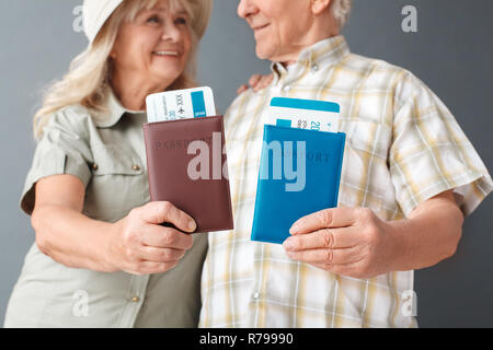 Touristes studio isolés sur shwoing gris Passeports et billets close-up arrière-plan flou smiling happy Banque D'Images