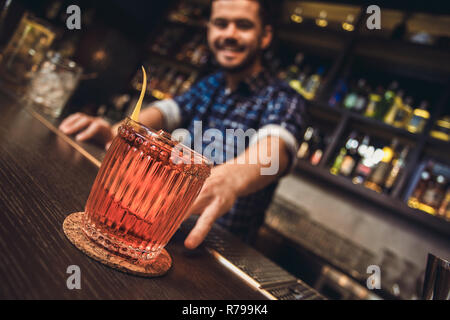 Jeune barman debout à comptoir bar cocktail close-up Banque D'Images