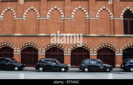 Profil d'une rangée de taxis ou les taxis noirs de Londres sur une rue en face d'un bâtiment de ville with copy space Banque D'Images