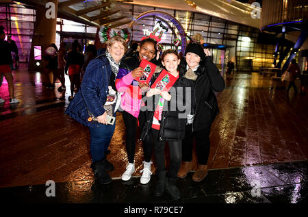 Les membres de l'auditoire posent à l'extérieur de l'arène O2 au cours de la première journée de la capitale Jingle Bell Ball avec Coca-Cola au London's O2 Arena. Banque D'Images